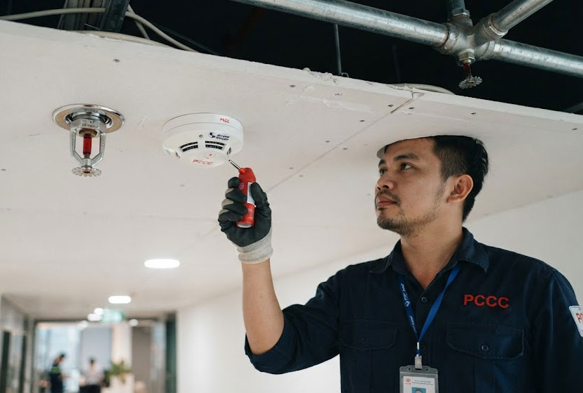 Kỹ sư kiểm tra vị tr&iacute; sprinkler v&agrave; đầu b&aacute;o kh&oacute;i khi cải tạo nội thất chung cư